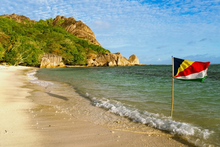 A Seychelles flag on a beach next to the ocean